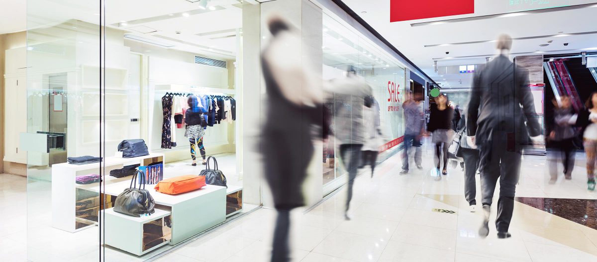 Blurred people in motion outside a retail store entrance